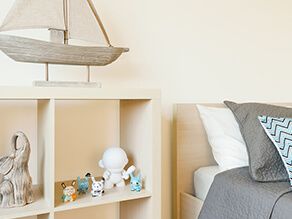 Neutral_kids_bedroom_toddler_minimalistic_timber_cube_shelving_timber_boat_ornament_grey_blanket